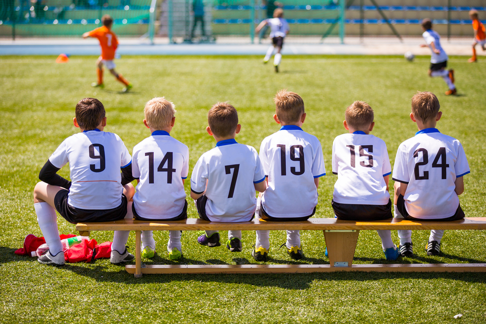 Kid's Sitting on a Soccer Bench